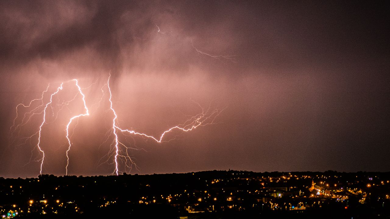 Gece şehir üzerinde yıldırımlı fırtına